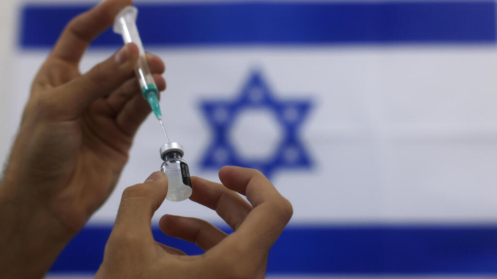 An IDF paramedic prepares a Pfizer COVID-19 vaccine to be administered at a medical center in Ashdod 