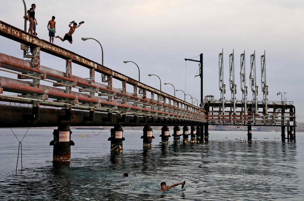 Youths jump into the Red Sea water off an abandoned oil jetty in Eilat, Feb. 2021 