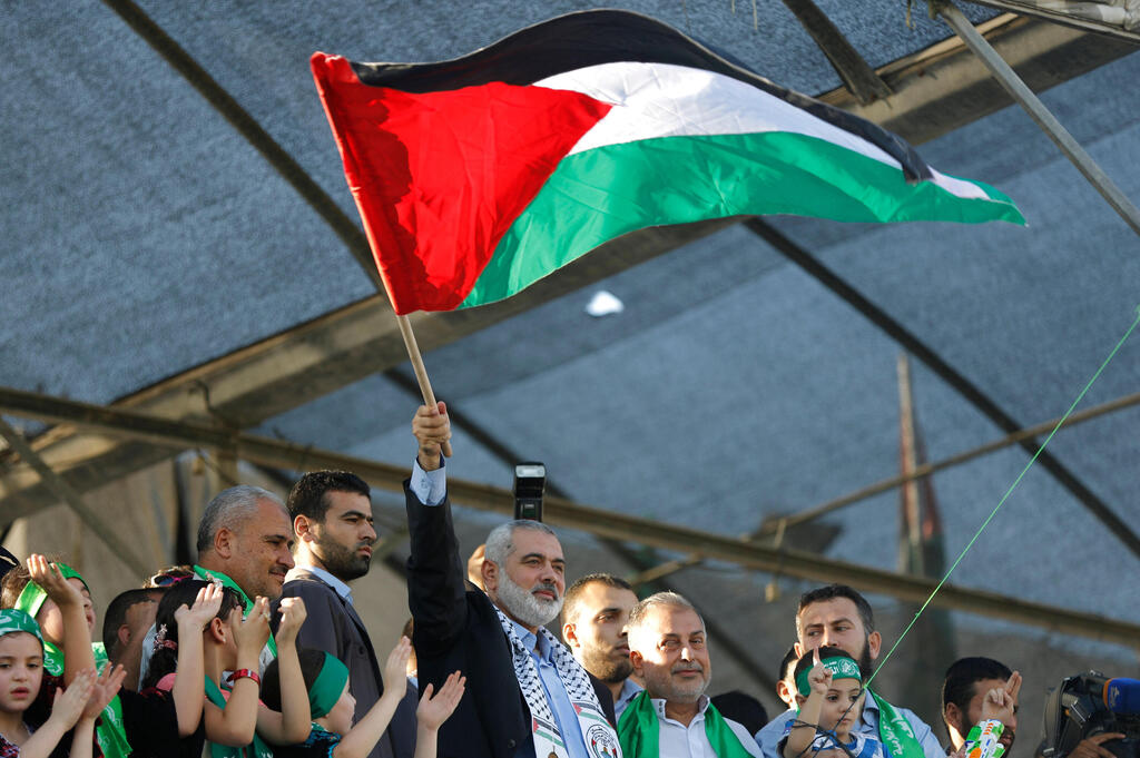  Hamas' top leader in the Gaza Strip Ismail Haniya (C) waves the Palestinian flag during a rally in Gaza C