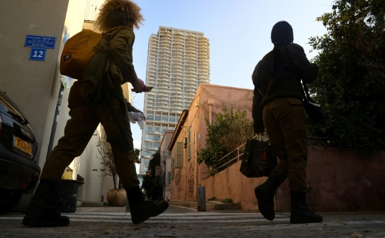 soldiers walk past a house in Tel Aviv 