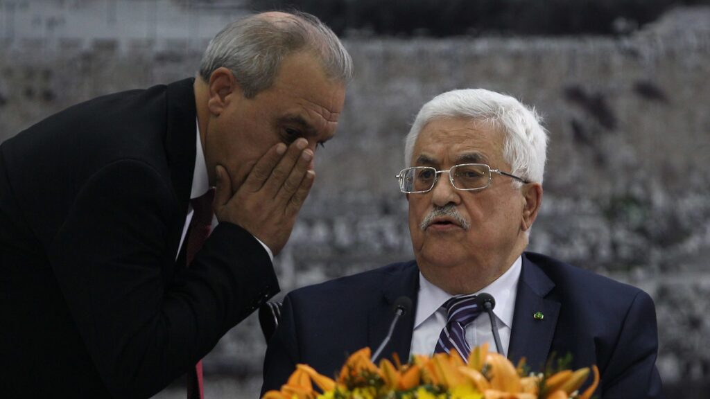 Director of Palestinian General Intelligence in the West Bank Majid Faraj whispers to Palestinian President Mahmoud Abbas during a meeting in Ramallah, April 2014  