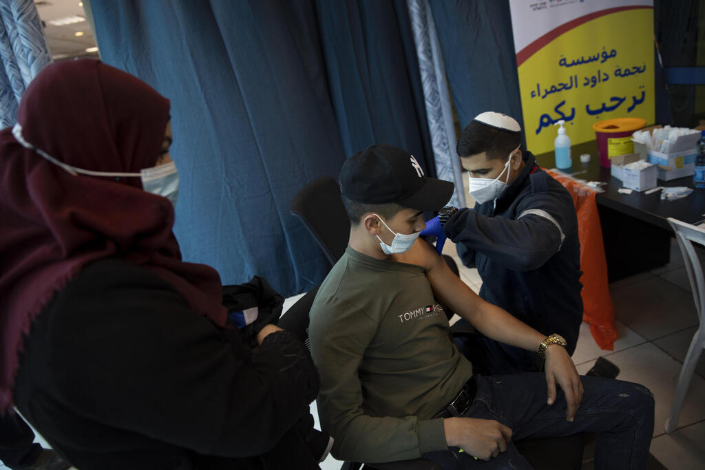 Israeli medics administer the Pfizer coronavirus vaccine to Palestinians at the Qalandia checkpoint between the West Bank and Jerusalem, Feb. 23, 2021 