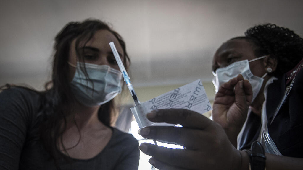 A health care worker is shown a Johnson & Johnson Covid-19 vaccine at the government hospital in Klerksdorp, South Africa,