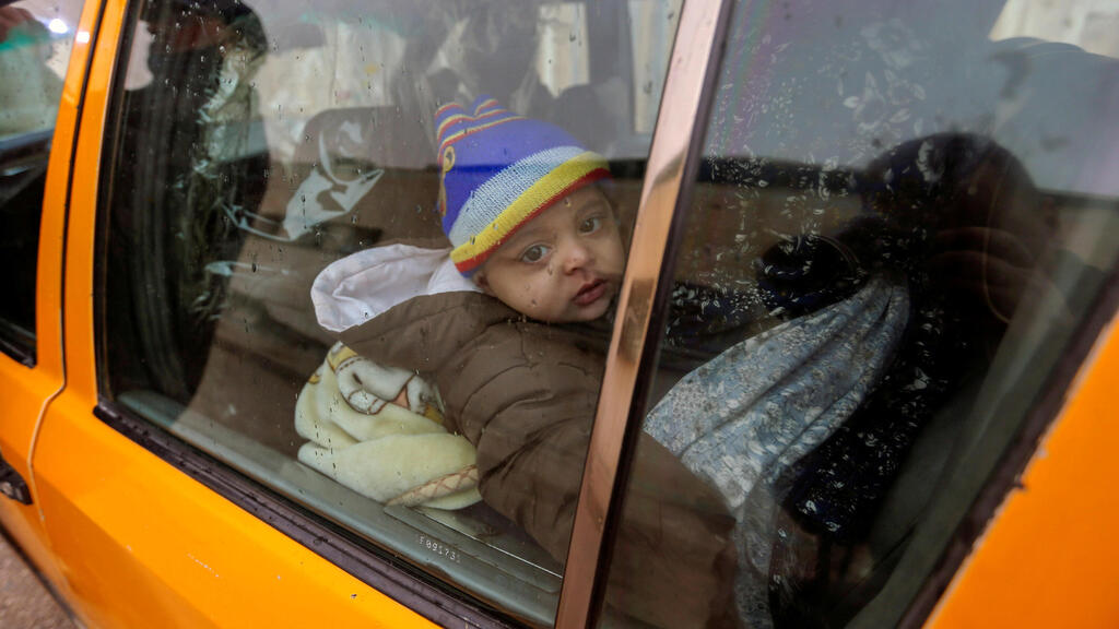 A Palestinian boy looks out of a car window as he waits to leave Gaza with his family through Rafah border crossing