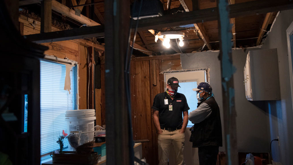 Technician Troy Watts discusses the damage caused to the home of Willie Hunt after his pipes burst in the unprecedented winter storm that swept across Texas, Feb. 22, 2021 