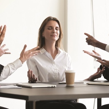 אישה עוצמת עיניים בישיבה במשרד