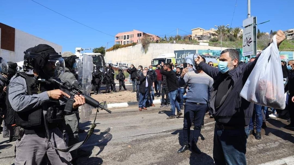 שוטרים מכוונים נשק למפגינים בהפגנה נגד האלימות באום אל פחם