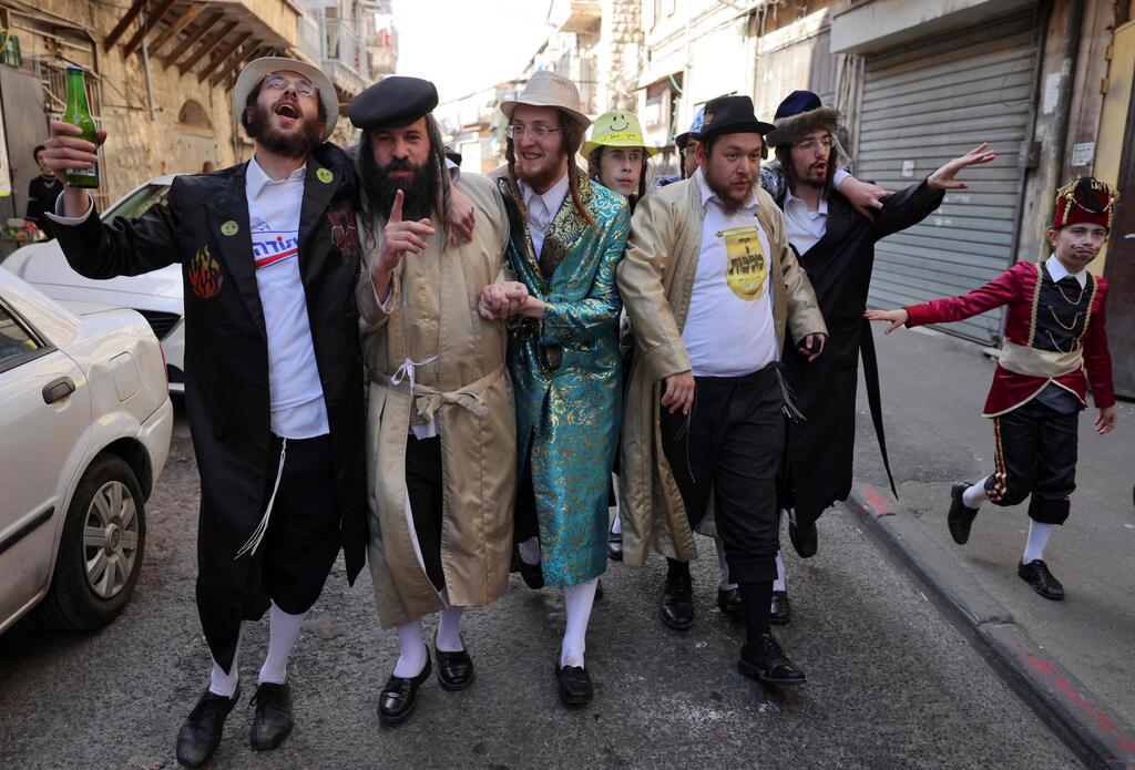 Residents of the Haredi neighborhood of Jerusalem violating health regulations during Purim in February (Photo: AFP) מתחפשים במאה שערים בירושלים