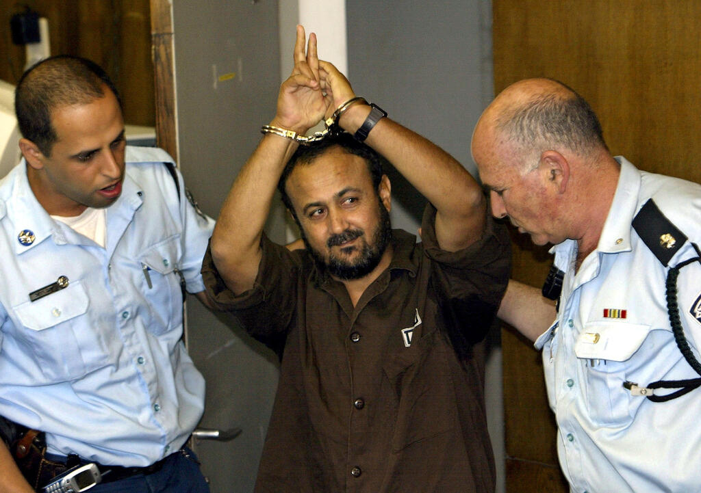 Marwan Barghouti, a popular Palestinian leader, gestures as Israeli police bring him into the District Court for his judgment hearing in Tel Aviv May 20, 2004/