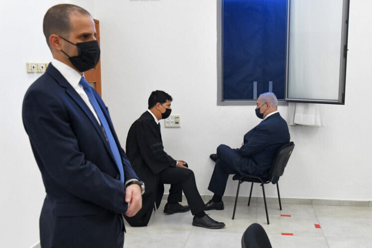 Prime Minister Benjamin Netanyahu (R) talks to his lawyer ahead of a hearing in his corruption trial at the Jerusalem district court, on February 8, 2021 