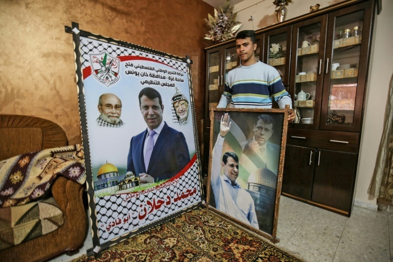 A member of Mohammed Dahlan's family displays pictures of the exiled Palestinian politician at their home in the Khan Yunis 