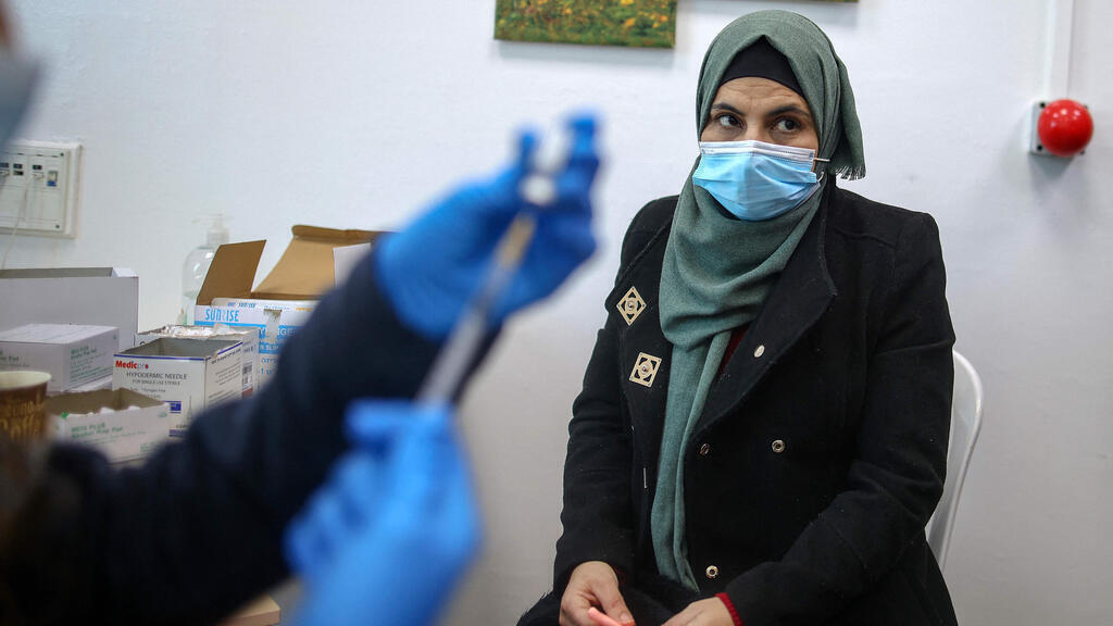 A Palestinian woman receives her coronavirus vaccine on the West Bank 