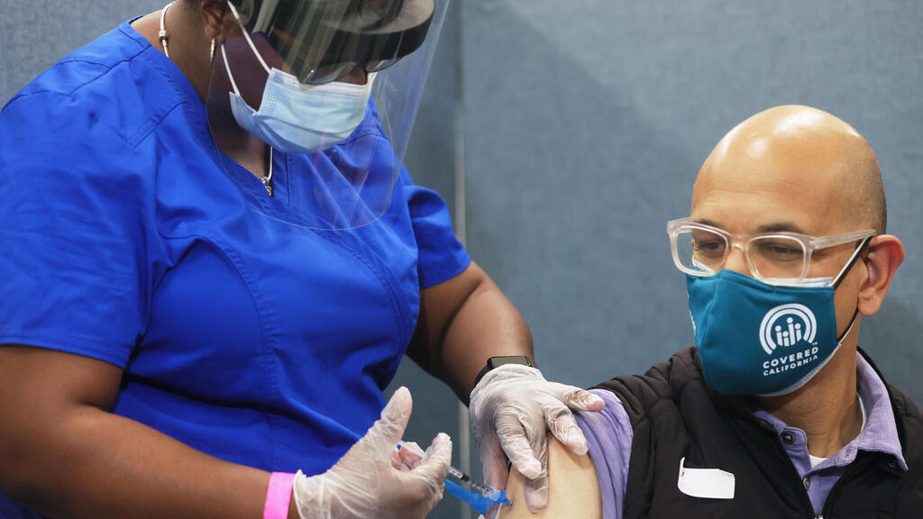 American man receives a dose of the coronavirus vaccine in March (Photo: AFP) מתחסנים בארה"ב נגד קורונה