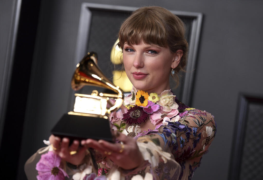 Taylor Swift poses in the press room with the award for album of the year for "Folklore" at the 63rd annual Grammy Awards at the Los Angeles Convention Center 