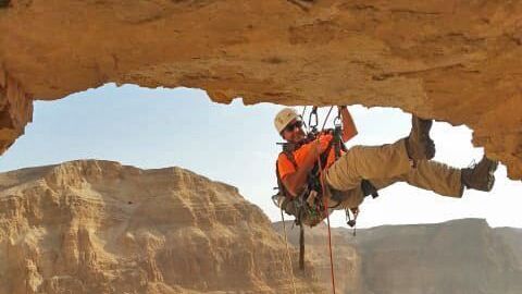 An archeologist rappels down the cliff into the Horor cave in the Judean Desert where rare discoveries were made 