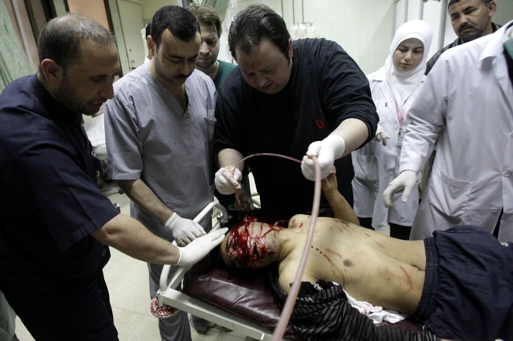 doctors treat a wounded man injured during clashes between Syrian security forces and anti-government protesters in 2011