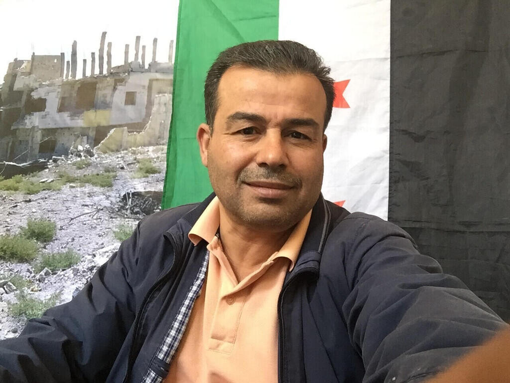 Ahmed al-Masalmeh, in front of the Syrian revolutionary flag, in Daraa 