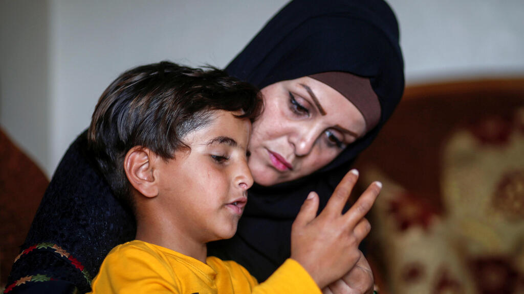  Niveen Gharqoud sits with her son Amir at their home in the central Gaza Strip March 15, 2021 