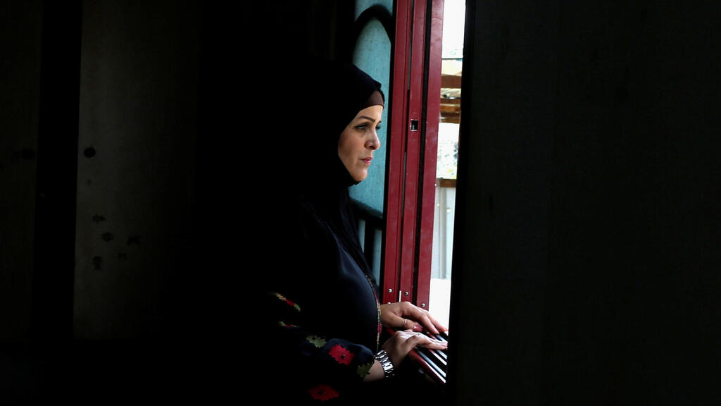 Niveen Gharqoud looks out from her home in the central Gaza Strip March 15, 2021. Picture taken March 15, 2021 