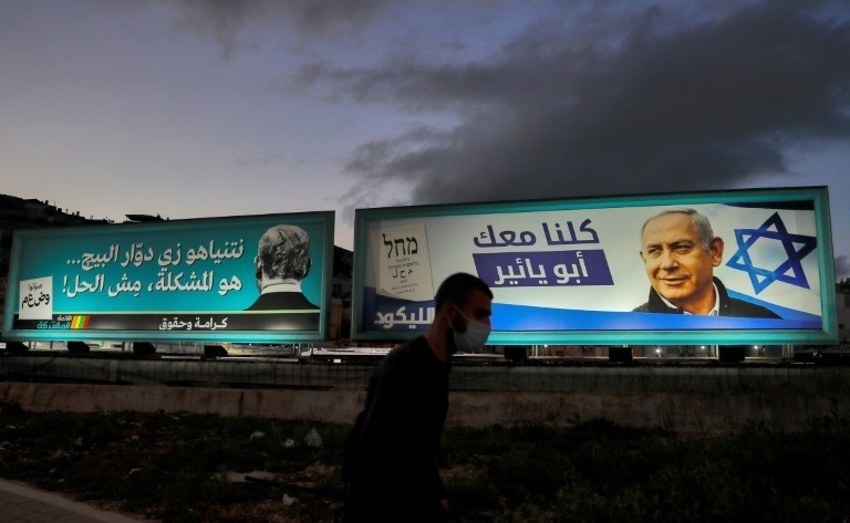 Election campaign billboards for the predominantly Arab Israeli electoral alliance the Joint List (L) and for Israel's right-wing Likud party, bearing a picture of its leader Prime Minister Benjamin Netanyahu 