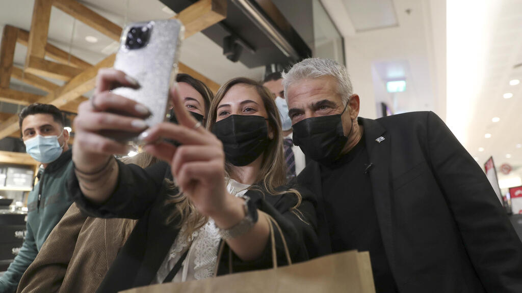 Yesh Atid leader Yair Lapid poses for a selfie with supporters as he campaigns at a mall in Haifa 