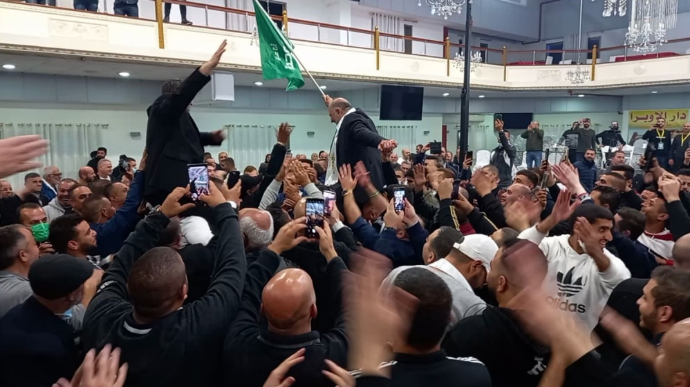 Abbas (holding flag) and Ra'am supporters celebrate electoral gains in election for 24th Knesset