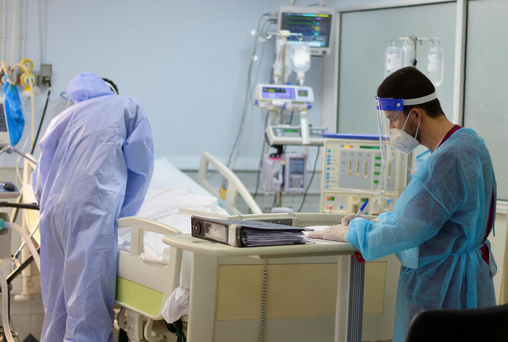 Medical staff members assist a patient suffering from the coronavirus disease (COVID-19), in an intensive care unit at a hospital in Amman, Jordan