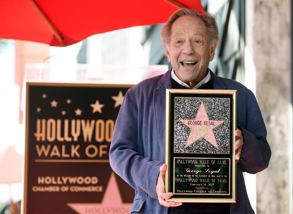 George Segal poses with a replica of his star at a ceremony honoring him on the Hollywood Walk of Fame in Los Angeles, Feb. 2017 