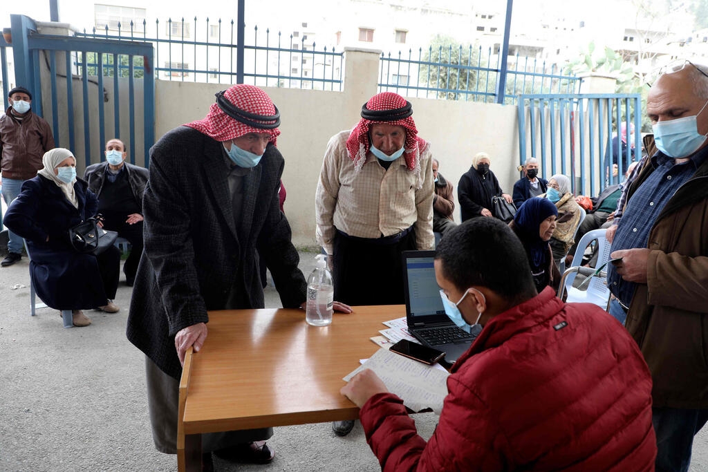 Palestinians register to get their shot of the Covid-19 coronavirus vaccine in the West Bank city of Nablus  