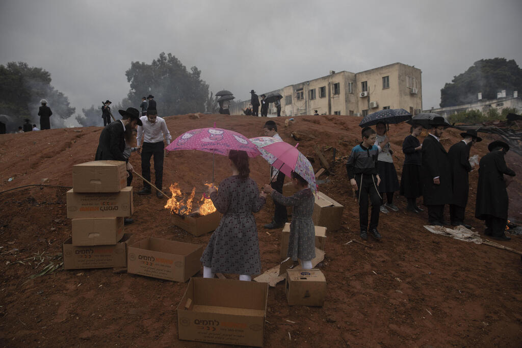 Ultra-Orthodox men and children burn leavened items in Bnei Brak ahead of Passover that begins Saturday night 