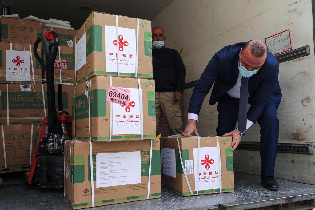 Staff members of the Palestinian Ministry of Health unload a shipment of the Sinopharm COVID-19 vaccines donated by the Chinese government in the city of Ramallah in the West Bank 