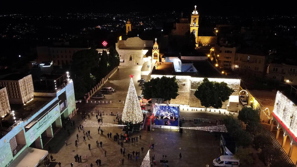 An aerial view shows people taking part in a Christmas tree-lighting ceremony in Manger Square outside the Church of the Nativity, during the coronavirus disease (COVID-19) outbreak, in Bethlehem, in the Israeli-occupied West Bank 