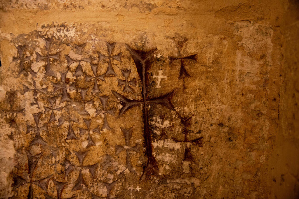 Crosses etched into the ancient stone wall of the Saint Helena chapel are seen inside the Church of the Holy Sepulchre in Jerusalem 