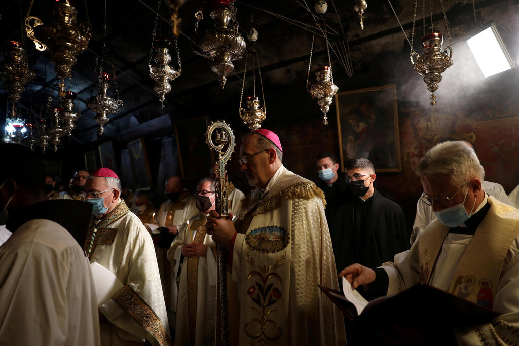 The Latin Patriarch of Jerusalem, Pierbattista Pizzaballa, leads a Christmas midnight mass at the Church of the Nativity in Bethlehem, the Israeli-occupied West Bank 