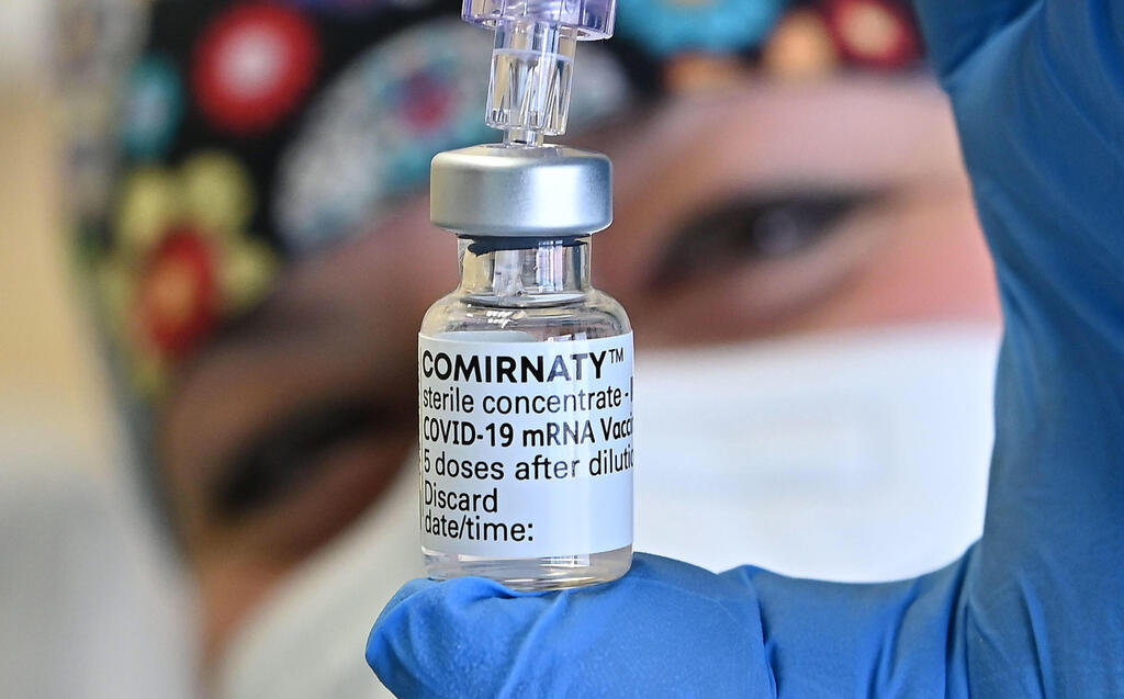 A nurse holding a vial of Pfizer's coronavirus vaccine 
