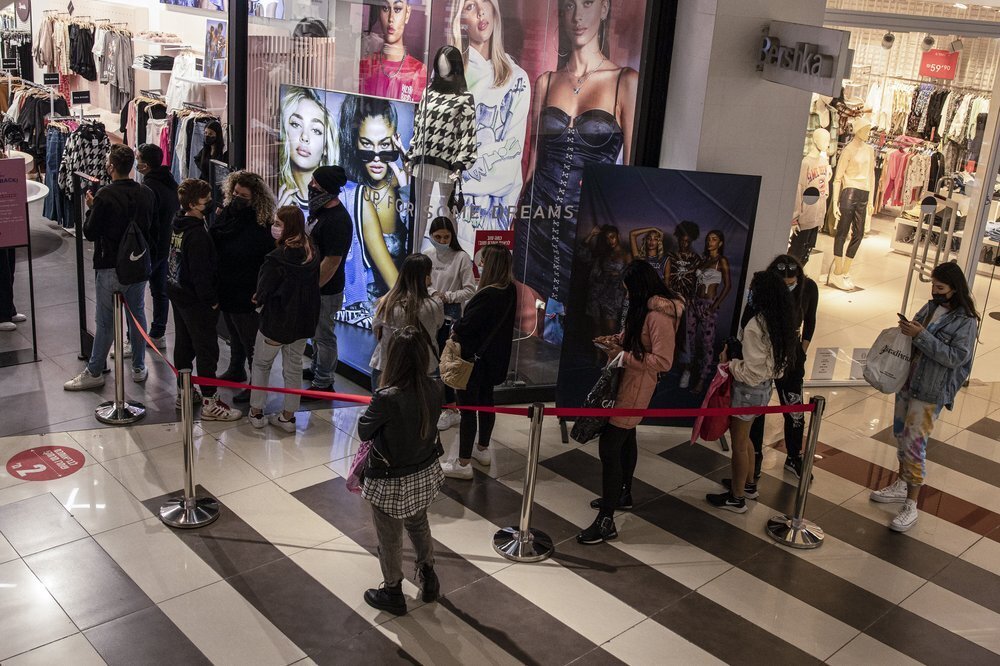 consumers line up to enter a clothing store at a shopping center in the city of Beersheba 