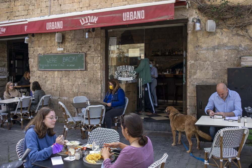 people eat in a restaurant as restrictions are eased following months of government-imposed shutdowns, in Tel Aviv 