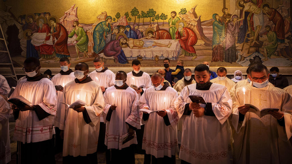 Priests wearing face masks pray during Easter Sunday Mass led by the Latin Patriarch at the Church of the Holy Sepulchre in the Old City of Jerusalem, April 4, 2021 