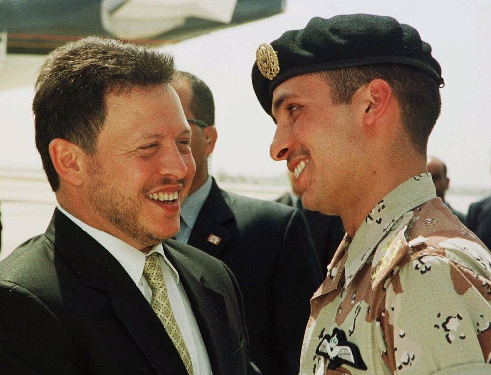 Jordan’s King Abdullah II laughs with his half brother Prince Hamzah, right, shortly before the monarch embarked on a tour of the United States 