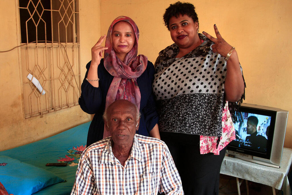 Amin Israil, the grandson of an Iraqi Jew who settled in Sudan and whose family later converted to Islam, with his daughter Salma, left, and Yosar Basha, another Sudanese woman of Jewish origin, at Israil's home in Wad Madani 