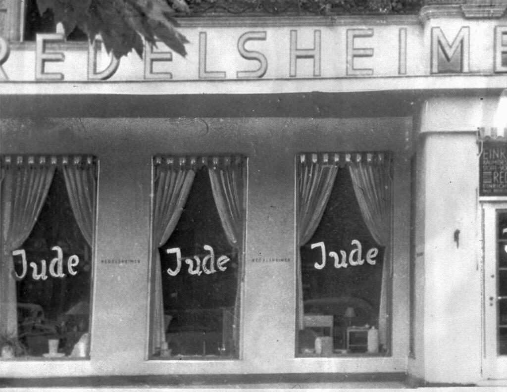 the word Jude (jew) is smeared to the windows of a shop in Berlin run by Jews. On Nov. 9, 1938 