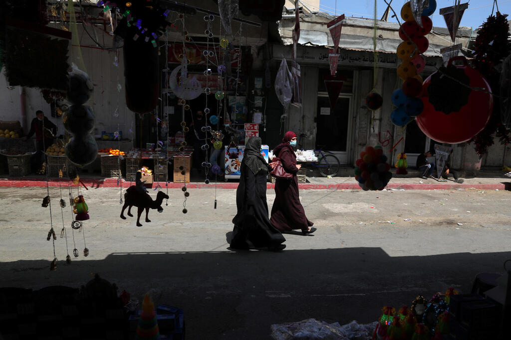 Palestinians walk as they shop at a market, ahead of the holy fasting month of Ramadan, in Gaza City April 5, 2021