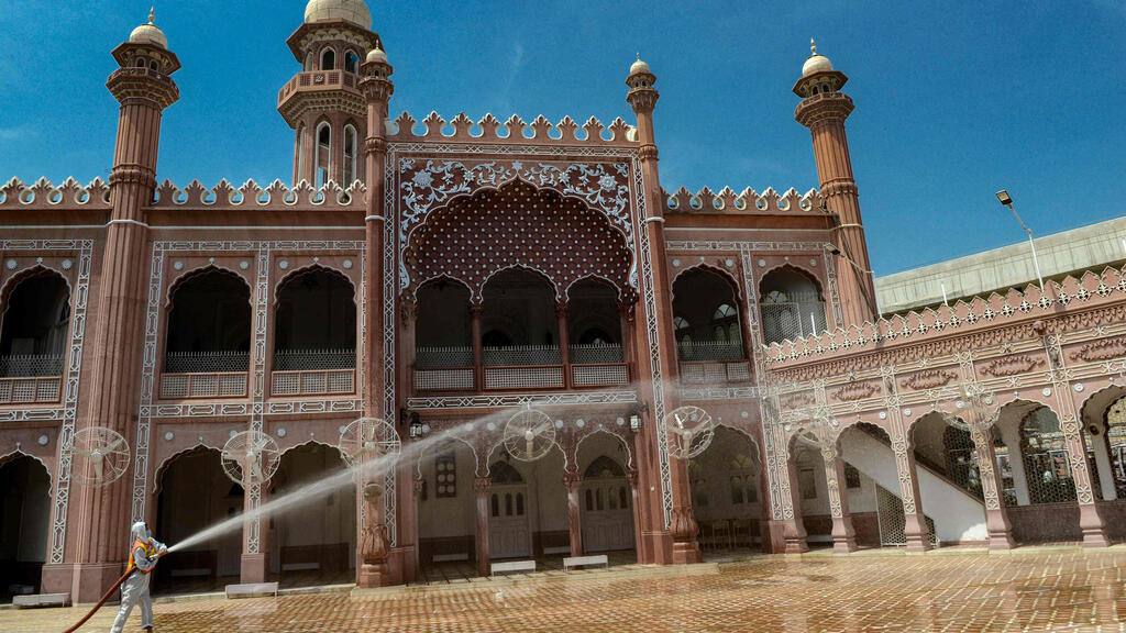 A worker disinfects a mosque during the Islamic holy month of Ramadan, in Peshawar 