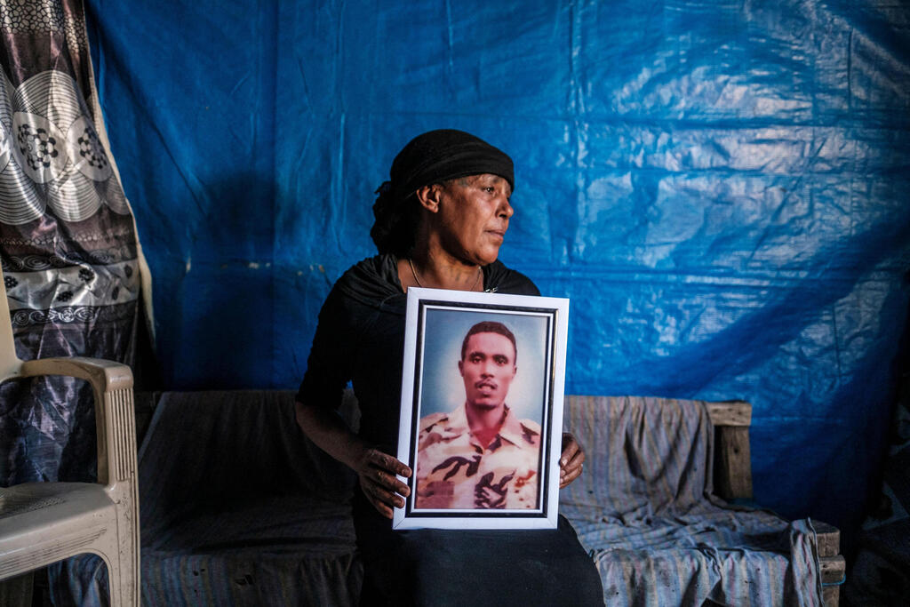 Azanu Girmay holds a portrait of her deceased son at her house in Gondar, Ethiopia 
