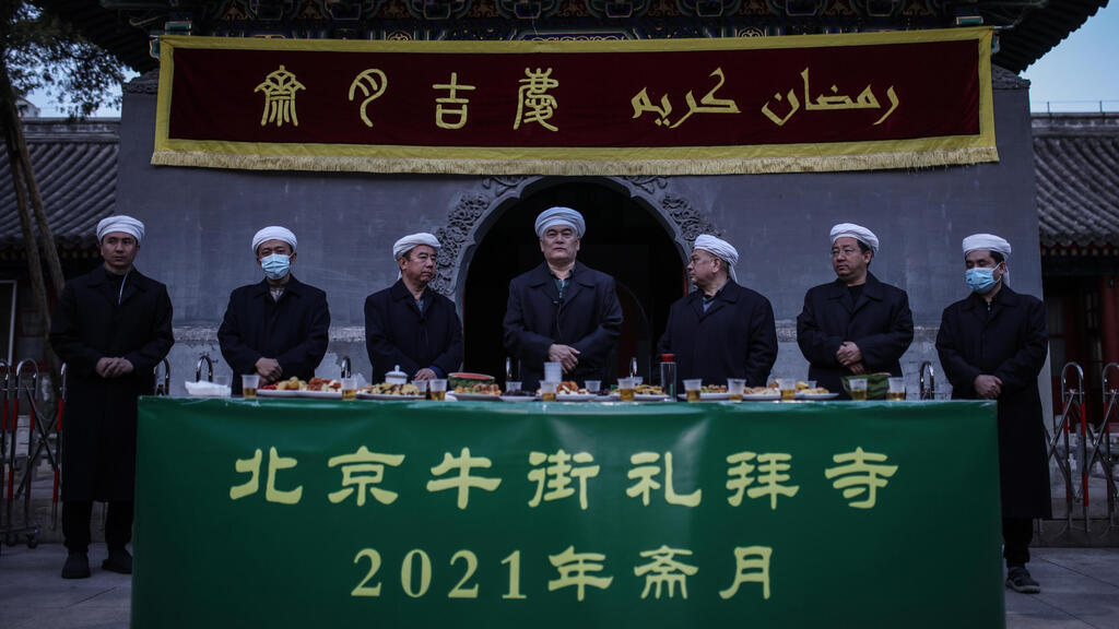 Muslim people pray before eat as they break fast with other devotees on the first day of the fasting month of Ramadan at the Niujie Mosque in Beijing city, China 