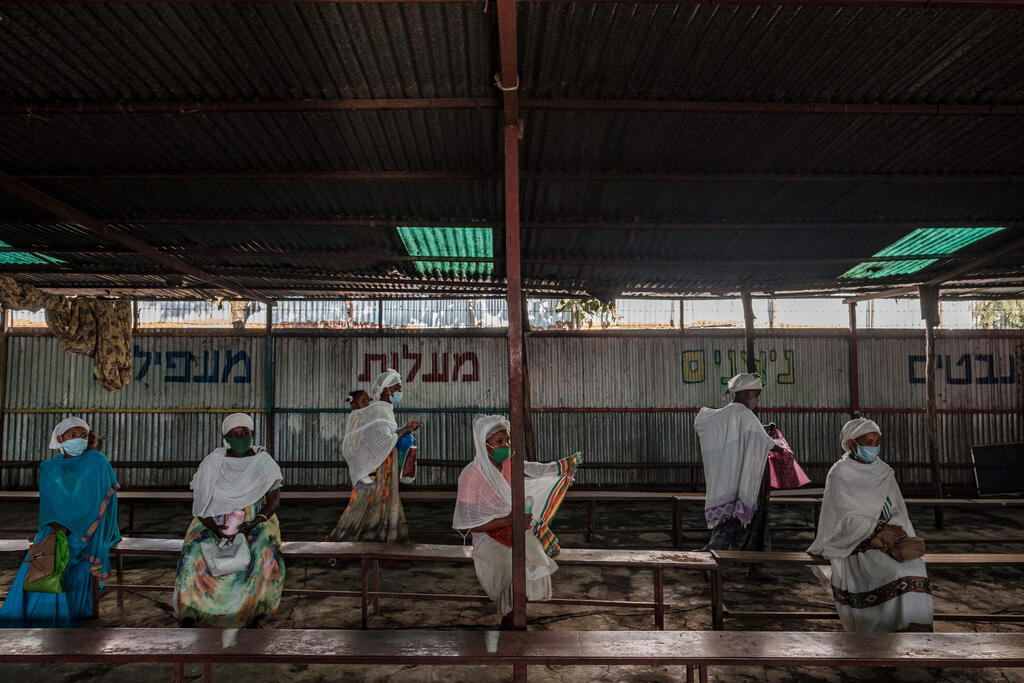 Members of the Ethiopian Jewish community await during the daily food distribution at the building the community in the city of Gondar, Ethiopia 