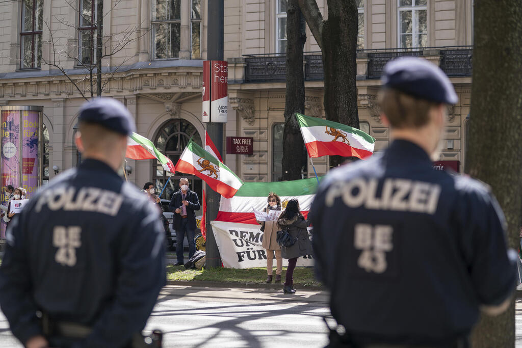 Protesters carrying the flag of an Iranian opposition group stand opposite police officers near the Vienna hotel as the nuclear talks with Iran were taking place last month 