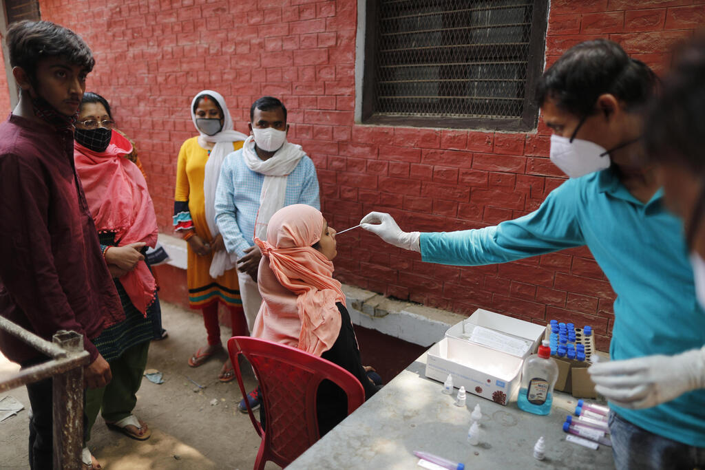 A health worker takes a swab sample to test for COVID-19 in the northern Indian city of Prayagraj, April 17, 2021 