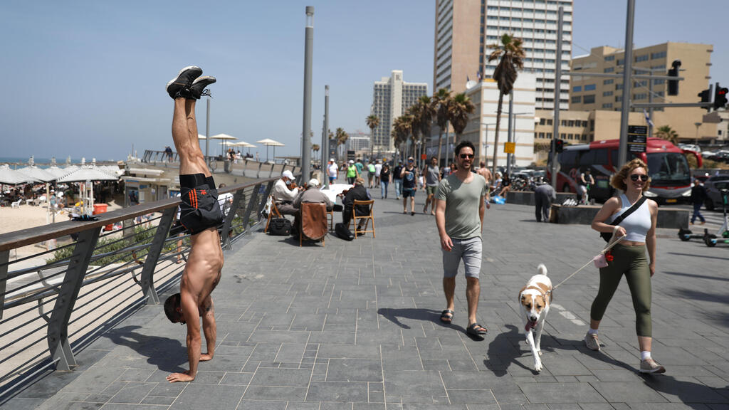 Israelis without face masks enjoy the spring sunshine in Tel Aviv on Saturday, a day before the mask mandate was officially lifted 