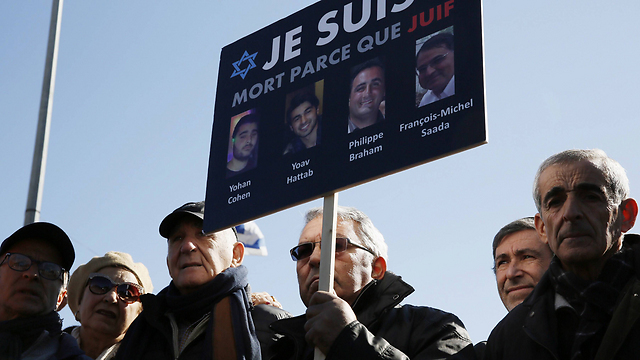 Mourners hold up images of the four victims of a deadly attack at a Paris kosher supermarket during their funerals in Jerusalem in January 2015 